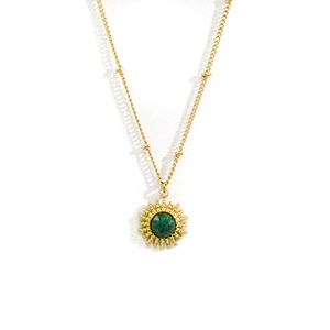 Dettaglio della collana d'oro 316L con ciondolo a raggiera e gemma verde al centro