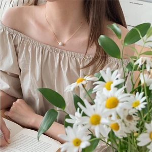 Elegant model wearing a minimalist 925 silver gold necklace with a single white pearl