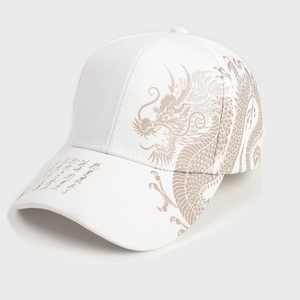 Detailed view of white baseball cap featuring golden dragon embroidery and calligraphy