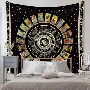 Detail of bohemian black and gold tapestry featuring tarot and zodiac symbols on wall