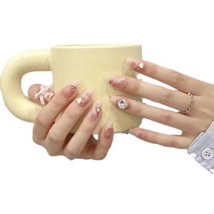 Handmade gradient pink press-on nails with 3D crystal bows and pearl accents