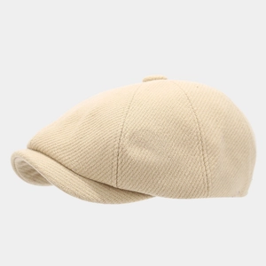 Classic beige newsboy cap with textured twill fabric and short brim in profile view