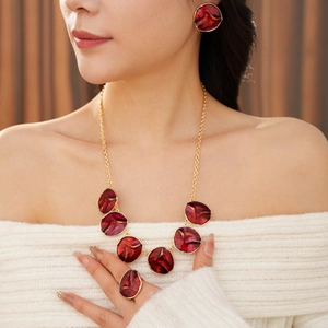 Detail view of model wearing a vintage gold-plated necklace, earrings and ring jewelry set