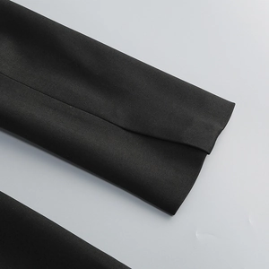 Detail of dark style black blazer dress showing twill woven fabric and sharp sleeve cuff