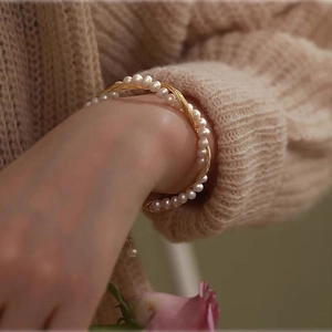 Handmade 14k gold filled braided bracelet with freshwater pearls on woman's wrist