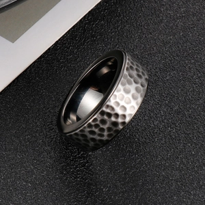 Macro shot of 8mm men's black titanium ring with hammered texture and polished inner band