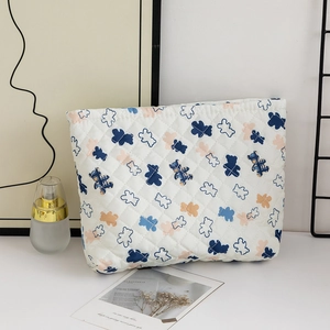 Quilted cotton storage bag with cute bear pattern and secure zipper on a soft desk setting