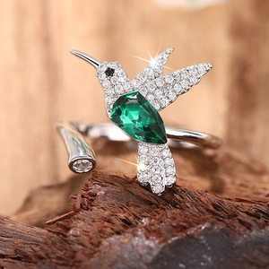 Macro-detail van de kolibrie-ring met groene peer-edelsteen en schitterende zirkonia-stenen