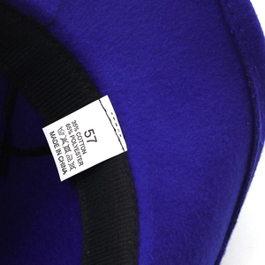 Detail view of cotton and polyester material label inside the blue wool jazz hat