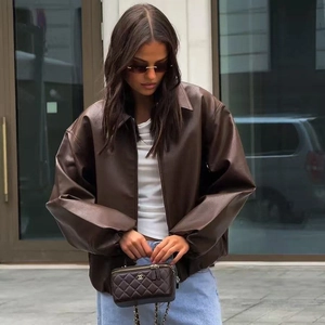 Detail of dark brown faux leather oversized bomber jacket with metallic zipper closure