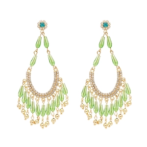 Vintage gold drop earrings with green crystal petals and blue rhinestones on white base