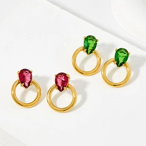 Elegant gold drop earrings with vibrant red and green zircon stones on a white stage