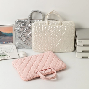 Quilted laptop sleeve bag in silver, beige, and pink with padded handles and zippers