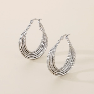 Macro detail of multi-layered silver twisted stainless steel hoop earrings with snap closure