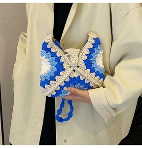 Detailed texture of blue and white crochet floral bag with elegant pearl button accent