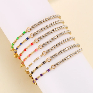Macro view of gold chain bracelets with colorful enamel accents and sparkling crystals