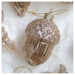 Detail of acorn Christmas ornament with pink glitter top and vertical striped glass base