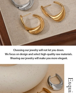 Détail des boucles d'oreilles créoles C géométriques en finitions or et argent polies