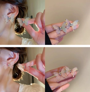 Detailed view of 3D gradient butterfly earrings with rhinestones and shimmer on model
