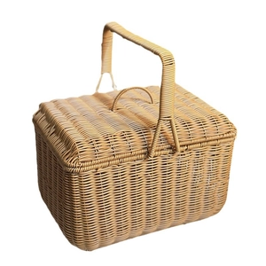 Handwoven wicker picnic basket with lid and handle in a natural wood finish