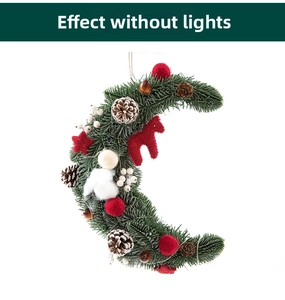 Detail view of moon-shaped Christmas wreath with faux pine, pinecones and red ornaments