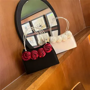 Detailed macro of vintage satin evening bags with 3D rose flowers and pearl handles