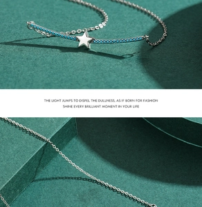 Detailed view of S925 sterling silver star pendant with turquoise bead on a dark surface