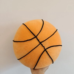 Macro shot of soft orange basketball plush pillow with black embroidery stitching details