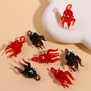 Detail view of red and black octopus-shaped glass pendants for DIY jewelry crafting