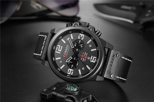 Detail view of sport chronograph watch with black leather strap and tactical gear