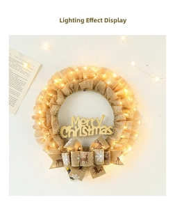 Close-up of a lit burlap Christmas wreath with Merry Christmas sign and warm LED lights