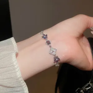 Elegant silver bracelet with purple floral crystals and zircon heart cutout pendant