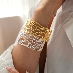 Detailed view of gold and silver open bangles with intricate woven mesh texture