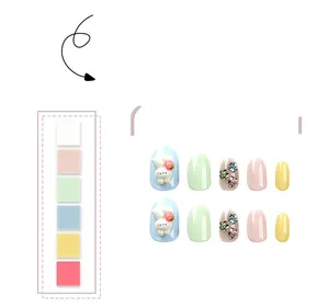 Detail of short round press-on nails featuring 3D white bunny and strawberry decorations