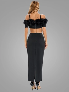 Detail of black off-shoulder crop top with feather trim and matching slit maxi skirt