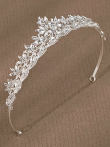 Close-up of silver bridal tiara featuring leaf floral motifs and sparkling rhinestones