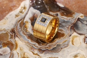 Macro detail of gold-plated stainless steel wide ring with black zircon and crystal stones