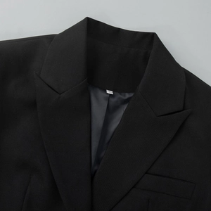 Detail of peaked lapel and stitching on a black lace拼接 blazer with satin lining