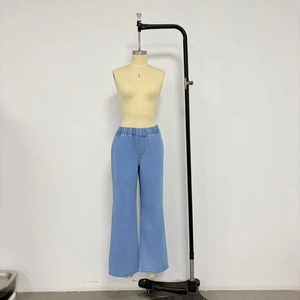 Dettaglio dei pantaloni in denim blu a gamba larga con vita elastica a pieghe per comfort
