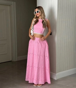 Détails de dentelle rose et liseré blanc sur le crop top sans manches et la jupe longue
