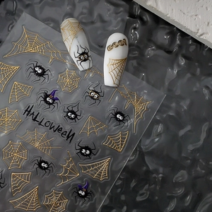 Macro view of Halloween nail stickers with gold spiderwebs and black spider motifs