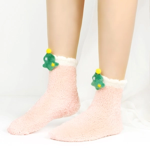 Detail von rosa Korallenvlies-Thermosocken mit grünem 3D-Weihnachtsbaum-Puppendekor