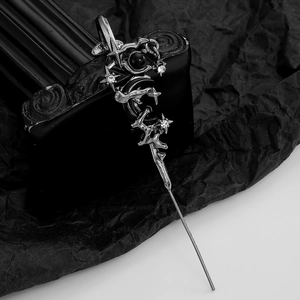 Close-up of gothic hair pin with star moon sword elements and sparkling rhinestones