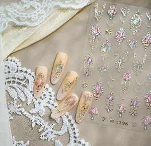 Close-up of M-1198 nail stickers with vintage gold embossed patterns and pink gemstones