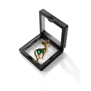 Vintage gold cat brooch with green crystals and blue eyes in a black gift frame