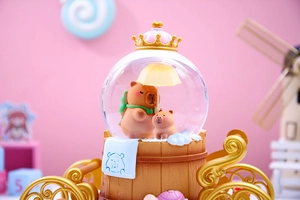 Macro view of Capybara crystal ball music box with golden crown and carriage base