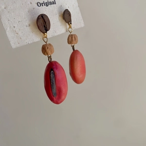 Detailed macro view of creative coffee bean earrings with realistic red coffee cherries
