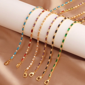 Detail of gold chains with multi-colored rectangular gemstones and round rhinestones