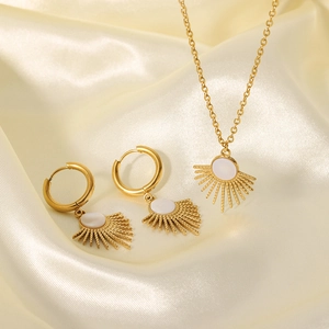 Detailed view of sunburst pendant and earrings set on soft silk fabric background