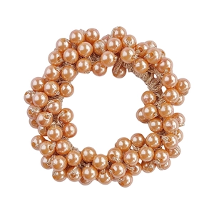 Detailed view of rose gold beaded elastic hair tie with glossy finish on white background